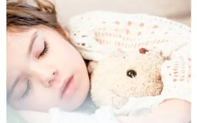 Young child asleep with a teddy
