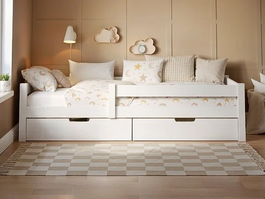 Wooden single bed with two pull-out storage drawers  styled in a neutral children’s bedroom with striped feature wall and soft patterned bedding