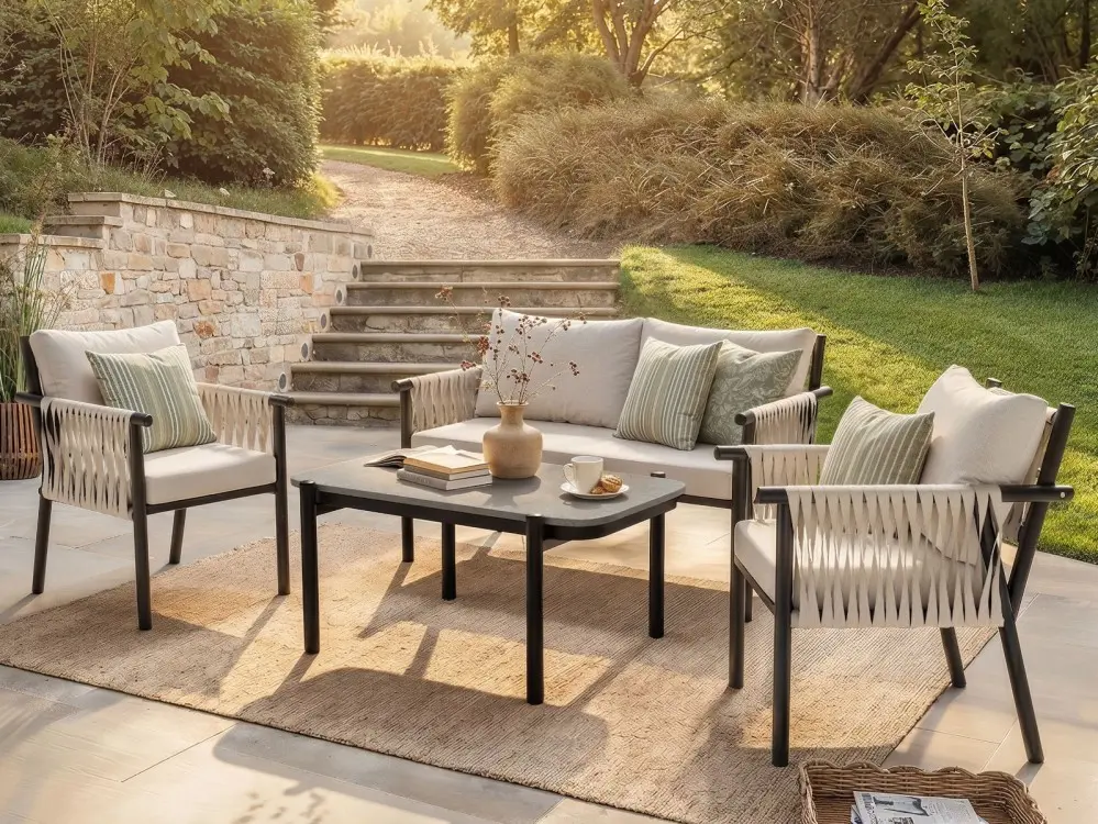 Four-piece garden sofa set with two armchairs, a two-seater sofa and a coffee table on a patio
